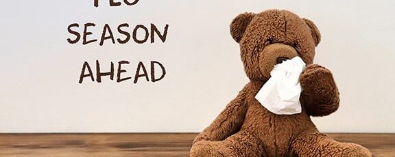 Flu: teddy bear with a tissue because of Coronavirus covid-19 (flu) with the words “flu season ahead” in the background
